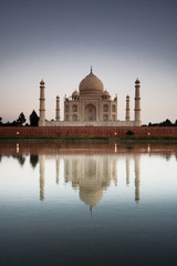 Fototapeta premium Taj Mahal reflected in river at twilight