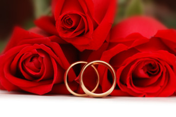 Two gold wedding rings  and red roses