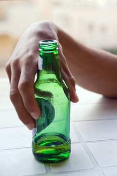 main de jeune homme et bouteille de bière addiction alcool 