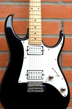 guitar on brick wall