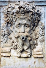artistic relief of the head on the fountain in Alhambra, Spain