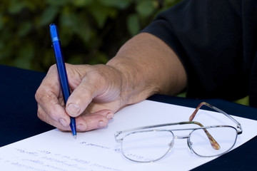 Naklejka premium Woman's hand holding a pen writing