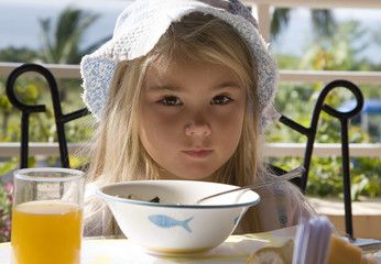 Little girl has a breakfast in the open air  