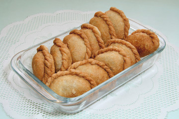 deep fried empanada served in a clear glass dish