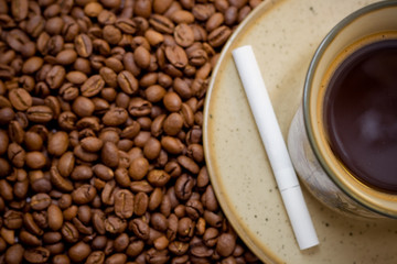 morning cup of coffee in beans with cigarete