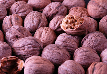 background with walnuts and one crushed walnut