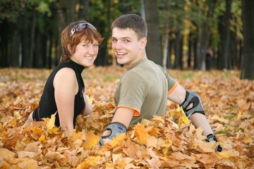 young couple of roller sits of leaves