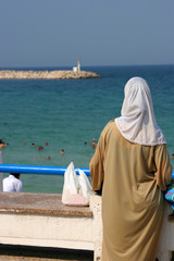 Muslim woman looking at the beach
