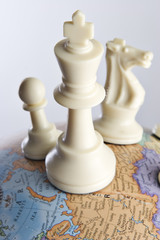 Chess pieces on an earth globe 