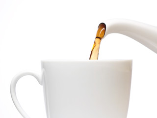 Tea pouring into white cup, close up