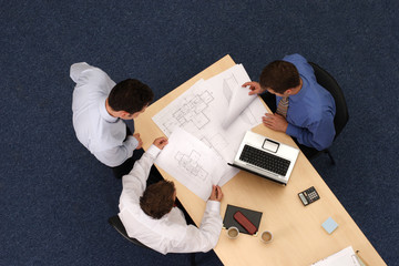 audit - three  business people  working over plans