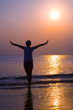 Girl walking along the coastline in sunset 2  