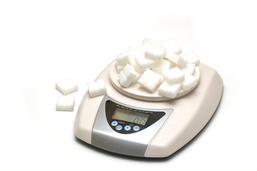 sugar and scale on white background