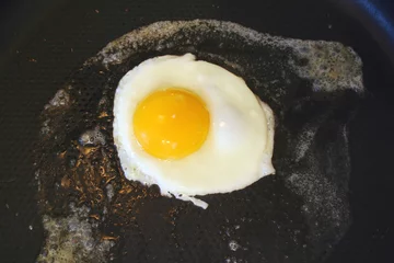 Tissu par mètre Oeufs sur le plat Sunnyside up egg frying in a pan