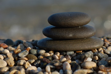 Fototapeta na wymiar three balanced rocks contrast a sea of stones