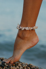 woman's foot with the sea shell bracelet