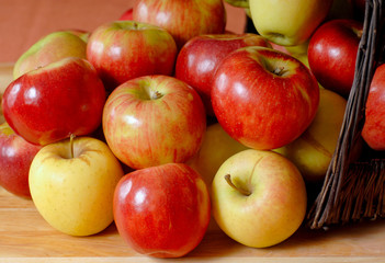 Basketfull of apples overflowing onto a table