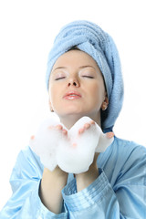 Beautiful girl with towel on her head and bath foam in her hands