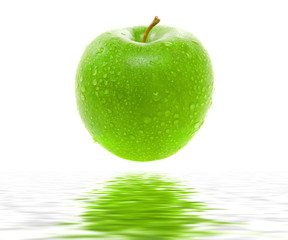 Wet juicy green apple over water. Isolated.