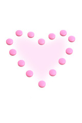 Heart from pink tablets on a white background