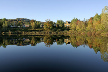 Fototapeta na wymiar autumn reflections on a lake in the morning