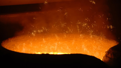 the intense glow of molten metal inside a furnace or smelting pot