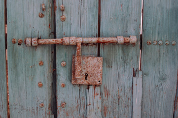 Puerta con cerrojo y candado oxidado