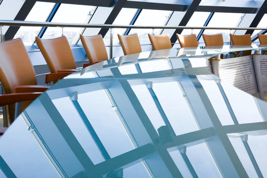 Modern boardroom interior with long conference table and set of chairs in glass office building. Suitable for business meetings, corporate presentations, office interiors