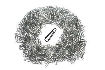 big isolated macro paper clip surrounded by many little