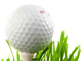 Closeup of a golf ball on a tee, isolated on white