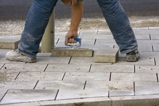 Arbeiter verlegt Gehwegplatten