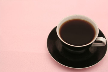 The black cup with fragrant coffee costs on a table