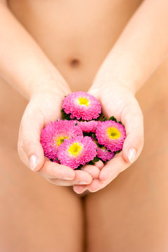 Naked woman holding flowers