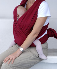 maman protant son bebe dans un foulard - obrazy, fototapety, plakaty