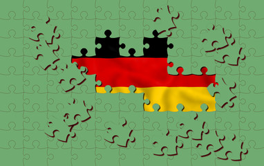 Obraz premium green puzzle pieces covering german flag