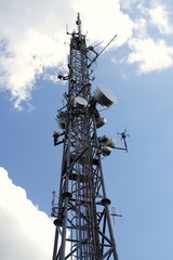 top of antenna mast under sky with clouds