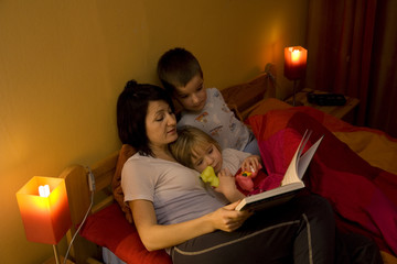Mother reading book children evening