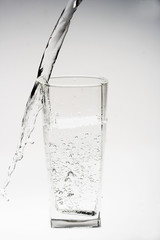 Glass of pouring water with reflection