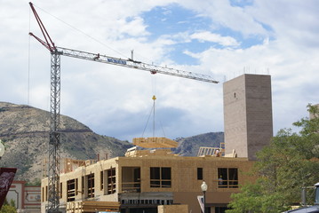 Fototapeta na wymiar Crane lifting material at a commercial construction site.