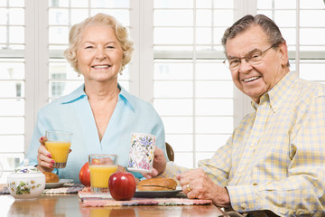 Mature couple eating breakfast.