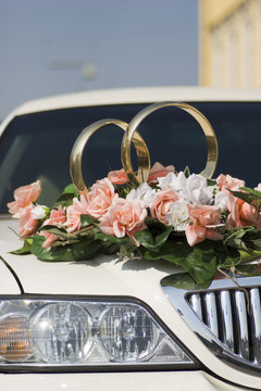 Flowers and rings by the wedding car