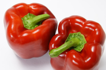 Two red peppers on white background
