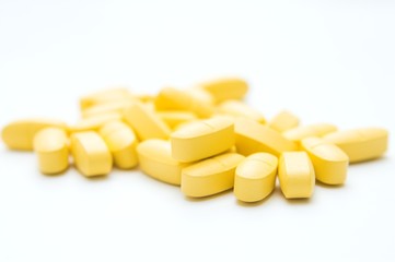 yellow pills over white background