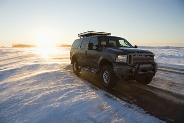 Fototapeta na wymiar Truck on icy road with snowy landscape.