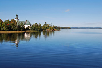 Fototapeta na wymiar Reflection of sky and church on placid lake in Sweden