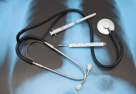 stethosocope, syringe and thermometer on x-ray photo