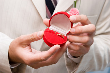 box with golden rings in hands