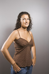 Fototapeta premium Portrait of brunette female with fingers in pockets smiling.