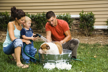 Family giving dog a bath.