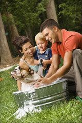 Family giving dog a bath. - 5331950
